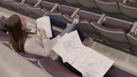Junior high drama teacher with script and sketches in theater seat Video stock 220945804