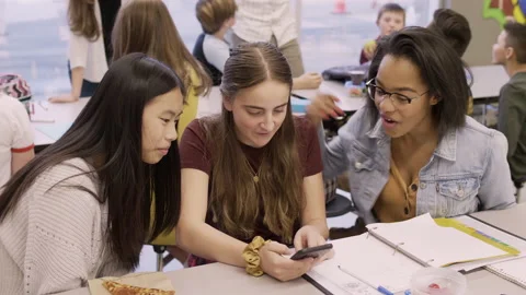 Junior high girl students using smart phone in school cafeteria Stock Footage 220945398