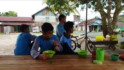 Junior high school boy eating and chatting with his friends Stock Footage 217180399