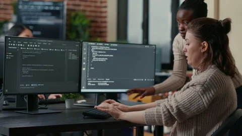 Junior programer writing algorithm under experienced colleague supervision Stock Footage 168248388