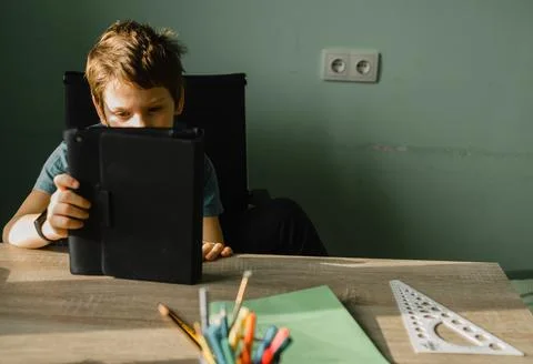 Junior school boy using tablet at home, growing up with technology Foto stock