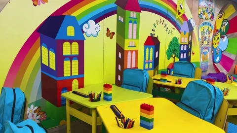 Junior school class. Yellow desks, blue backpacks and a play area for children Stock Footage 249757760