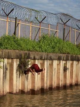 Junior schoolboy performed back-flip from pier into azure sea Stock Photos