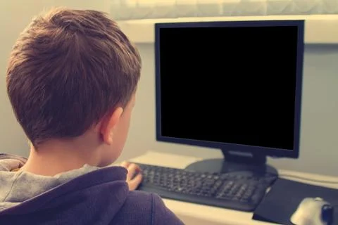 Junior schoolboy using Pc Investigating internet Browser for homework and pla Stock Photos