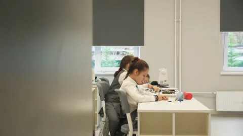 Junior students write in copybooks in school classroom Stock Footage 201583992