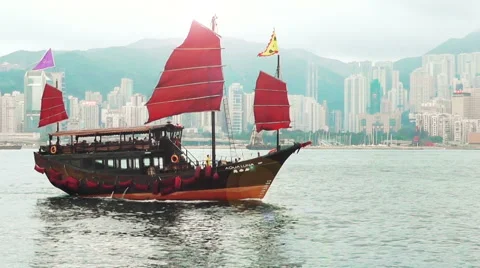 Junk boat with red sails is in Victoria Harbour, Hong Kong Stock Footage 61908586