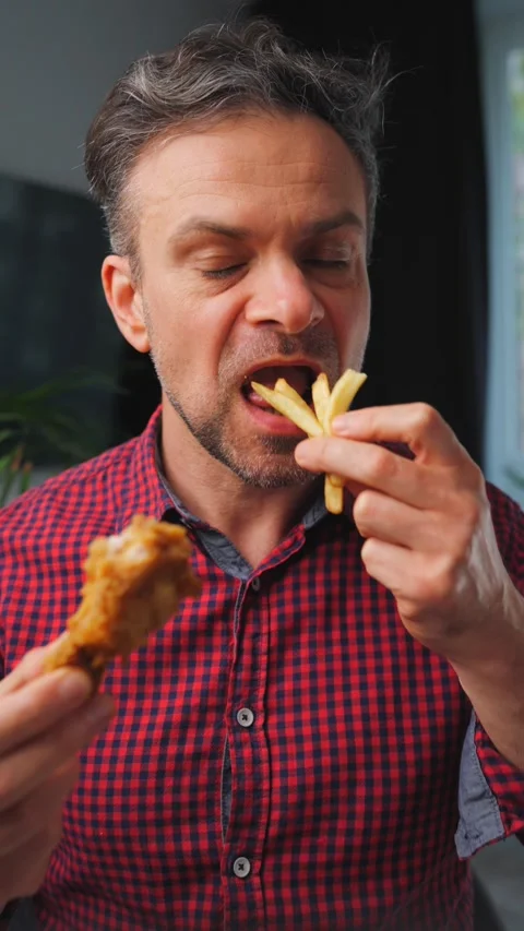 Junk food advertisement concept. Man eating fried chicken, enjoying fast food. Stock Footage 322185053