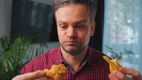 Junk food advertisement concept. Man eating fried chicken, enjoying fast food. Stock Footage 342834664