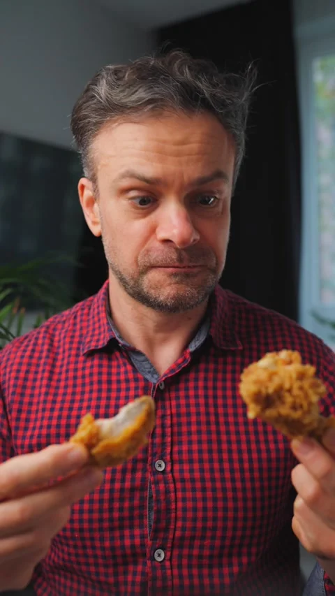 Junk food advertisement concept. Man eating fried chicken, enjoying fast food. Stock Footage 342834982
