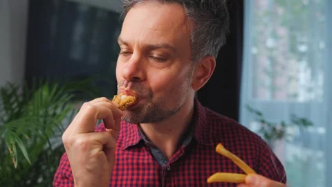 Junk food advertisement concept. Man eating fried chicken, enjoying fast food. Stock Footage 342956105