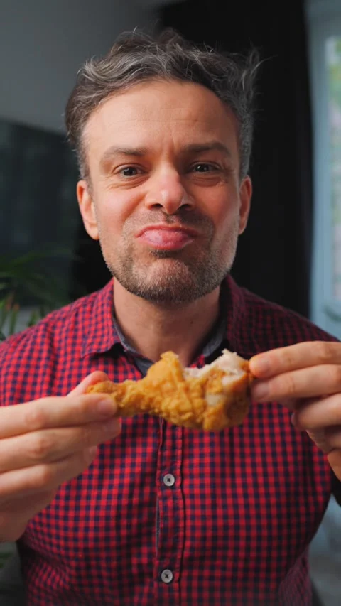 Junk food advertisement concept. Man eating fried chicken, enjoying fast food. Видео 342957911