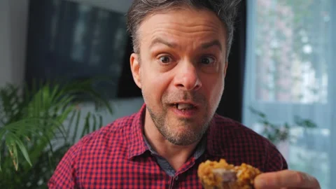 Junk food advertisement concept. Man eating fried chicken, enjoying fast food. Stockbeeldmateriaal 342958689