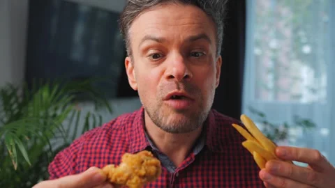 Junk food advertisement concept. Man eating fried chicken, enjoying fast food. Video stock 343447340