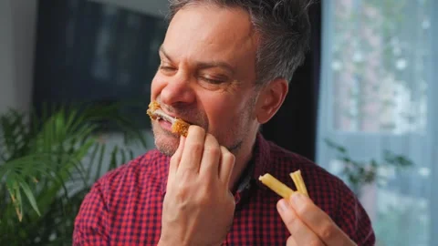 Junk food advertisement concept. Man eating fried chicken, enjoying fast food. Video stock 343448549