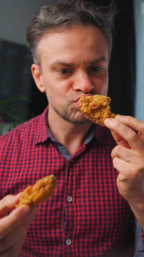 Junk food advertisement concept. Man eating fried chicken, enjoying fast food. Stock Footage 346728373