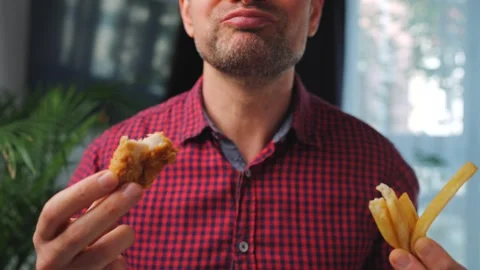 Junk food advertisement concept. Man eating fried chicken, enjoying fast food. Stock Footage 346728478
