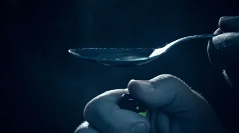 Junkie hand fire up the lighter over spoon boiling drug heroin. Slow Motion Stock Footage 48861833