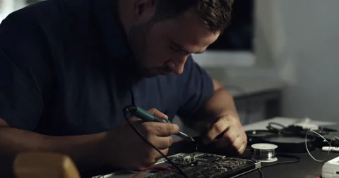 Just call him the electronic device doctor. 4k video footage of a young Stock Footage 201067310