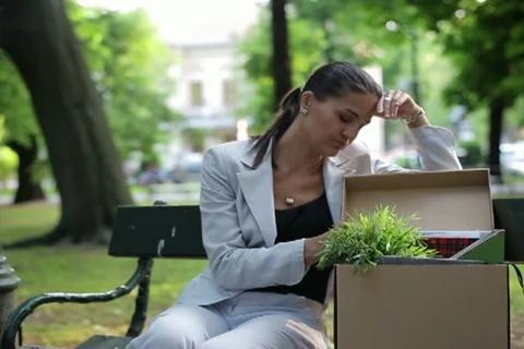 Just fired, unemployed sad young businesswoman sitting in the park NTSC Stock Footage