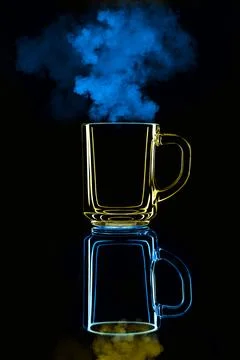 Just a glass on a black background with a reflection. Blue and yellow, with s Stock Photos