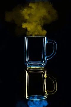 Just a glass on a black background with a reflection. Blue and yellow, with s Stock Photos