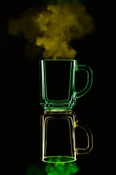 Just a glass on a black background with a reflection. Yellow and green, with  Stock Photos
