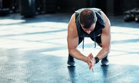 Just keep going and dont give up. a young man doing push ups in a gym. Stock Photos