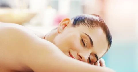 Just let your stress float away. Shot of a young woman relaxing on a massage  Stock Photos