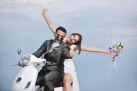 Just married couple on the beach ride white scooter Stock Photos