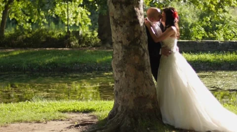 Just married couple kissing by the lake | Stock Video | Pond5