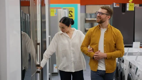 Just married couple open door of the refrigerator in the hardware electronics Stock Footage 279593113