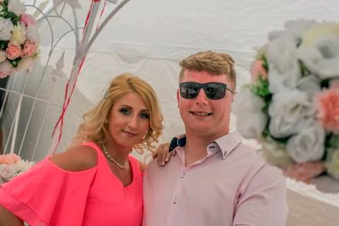 Just married couple posing between beautiful bouquets. Stock Photos