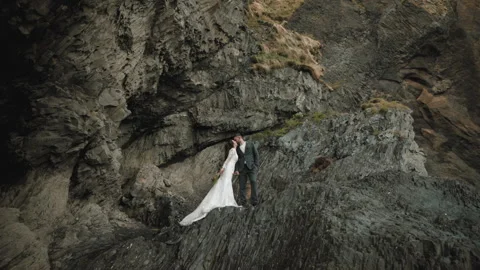 Just married couple standing in rocks, kissing. Reynisfjara beach, Iceland Stock Footage 254220344