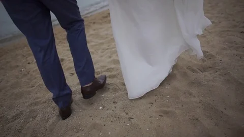 Just married couple walking on a sandy beach Stock Footage 73300417