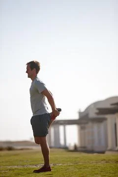 Just a quick stretch before his run. a man doing stretches before his workout. Stock Photos