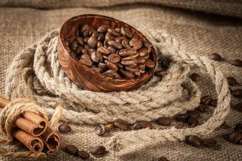 Jute bag on table surrounded by spilling coffee beans - rustic charm Stock Photos