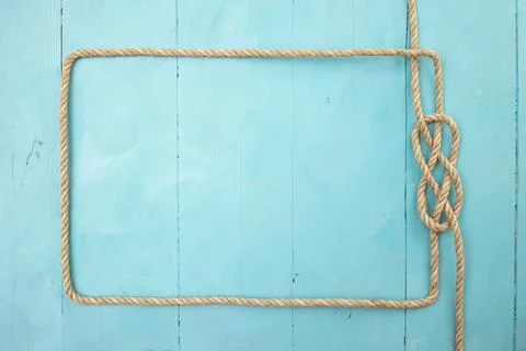 Jute rope rectangular frame, with a knot on blue painted boards Stock Photos