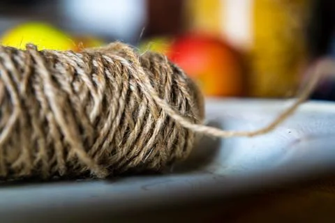 Jute string roll close up in vintage enamel plate on blurred background Stock Photos