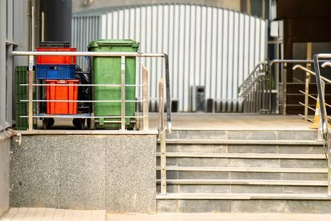 Juxtaposition of discarded plastic boxes and a trash bin against the backdr.. Stock Photos
