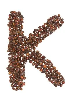 K letter made of cedar  nuts Stock Photos