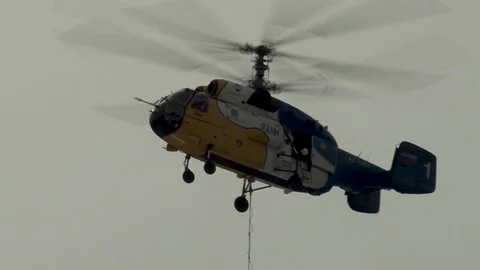 Ka-32 helicopter in hover mode at installation of metal structures of cableway. Stock Footage 106771826