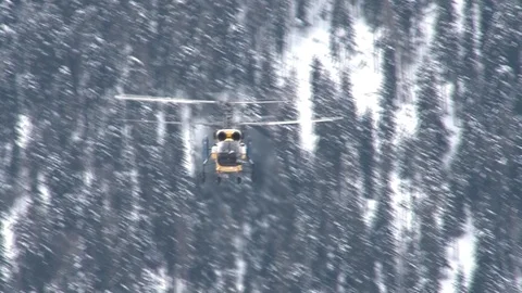 Ka-32 helicopter at installation of cableway against snow-capped mountains. Stock Footage 106491436