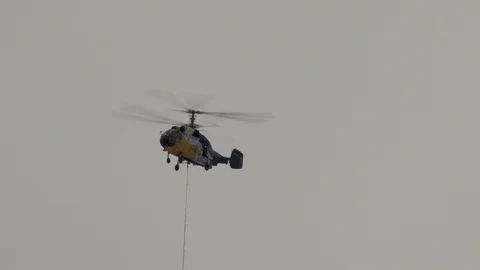 Ka-32 helicopter with load is flying to support of the cable car. Stock Footage 106062112