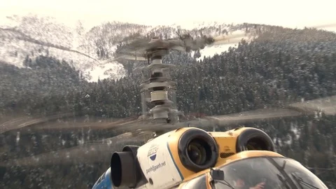Ka-32 helicopter with rotating rotor blades on background of snow-capped peaks Stock Footage 105778030