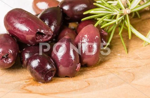 Kalamata olives and rosemary being prepared Stock Photos