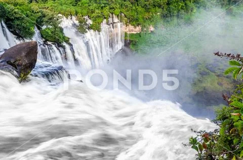 Kalandula waterfalls of Angola in full flow with lush green rain forest, rocks Stock Photos