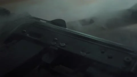 A Kalashnikov assault rifle is lying on the table, close-up. smoke from gunshots Stock Footage 206058909