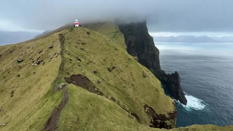 Kallur Lighthouse on the dramatic cliffs of Kalsoy Island with Borgarin rock  Stock Footage 335265755