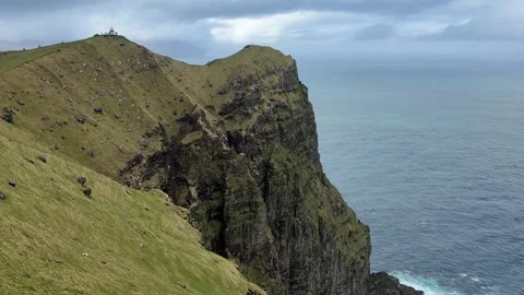 Kallur Lighthouse on the dramatic cliffs of Kalsoy Island with Borgarin mountain Video stock 335265763