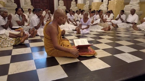 Kandy, Sri Lanka - 09-03-24 - Monk Leads Dozens of People Sitting on Floor in Stock Footage 109040207